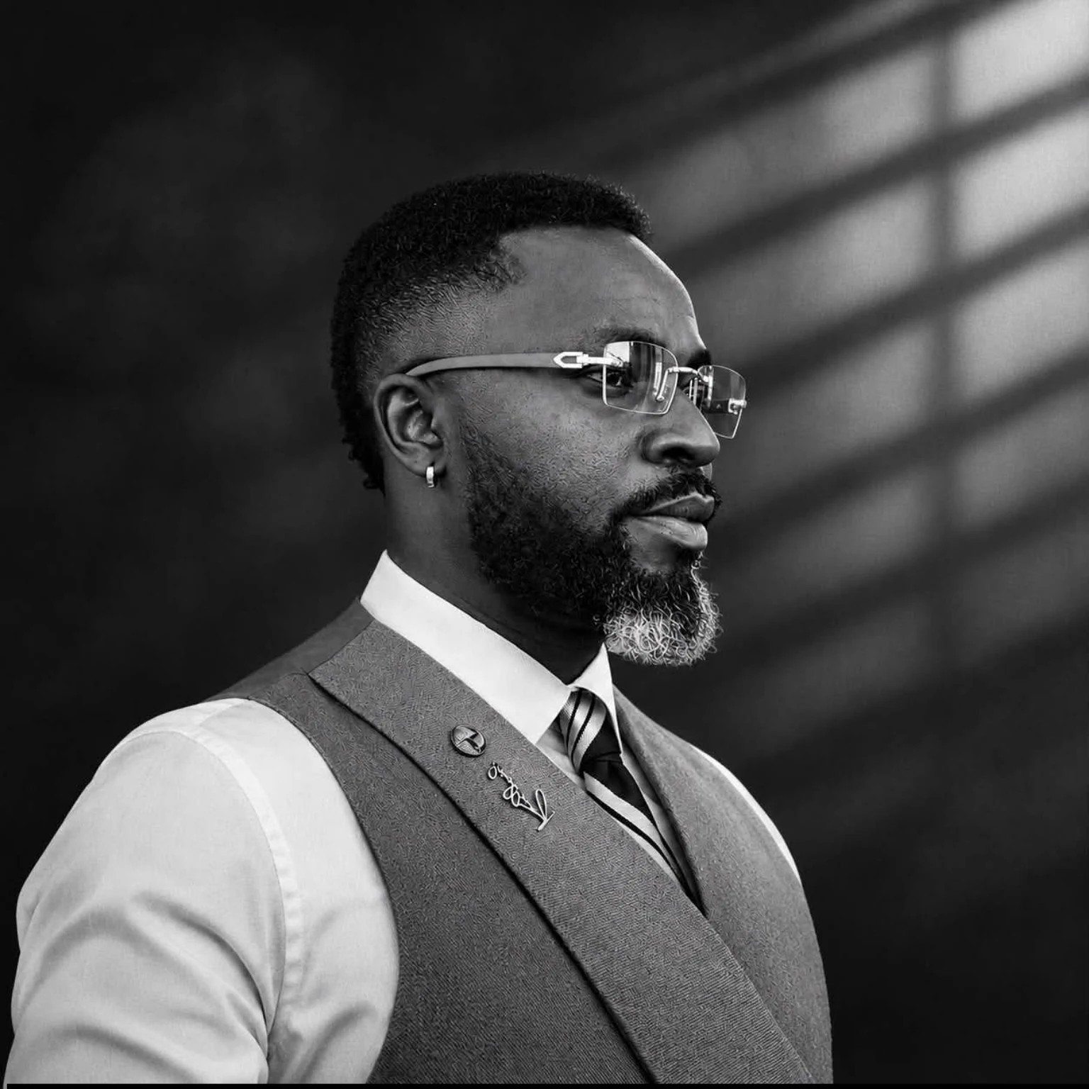 Black and white portrait of Ray Dynasty wearing glasses and a tailored waistcoat
